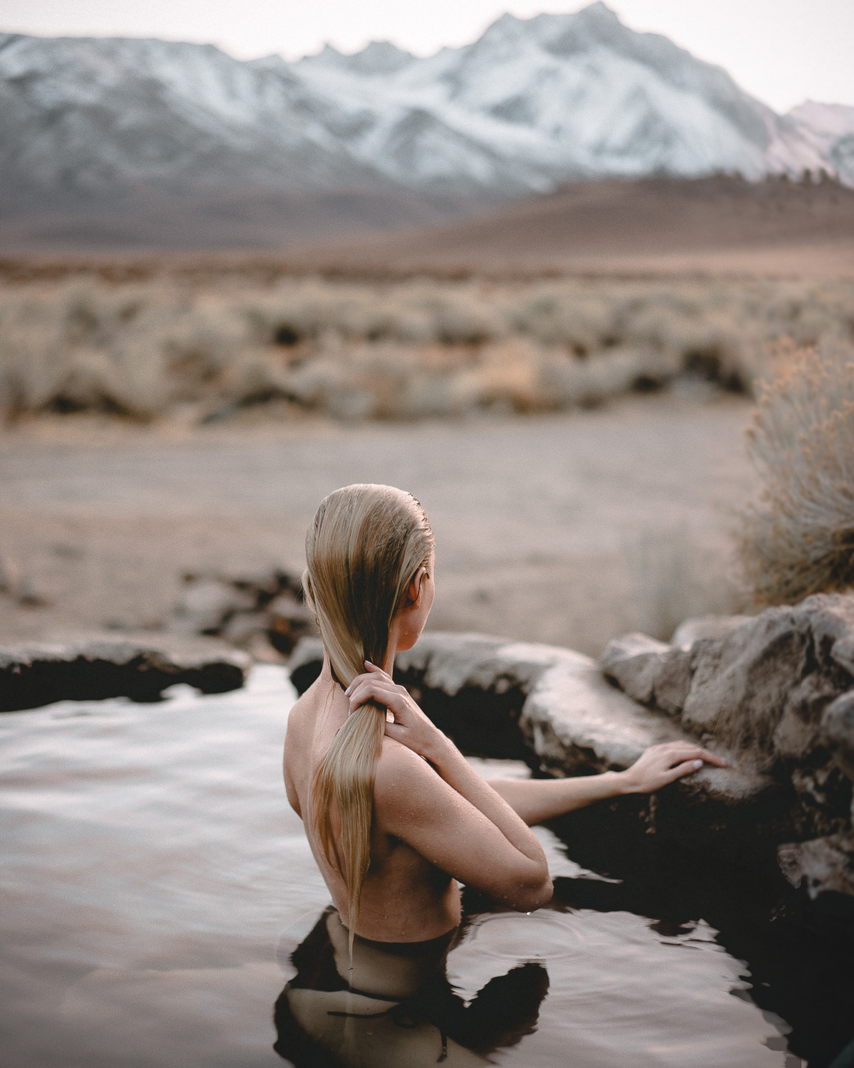 Girl Sits In The Rock Tub Hot Spring in Mammoth California