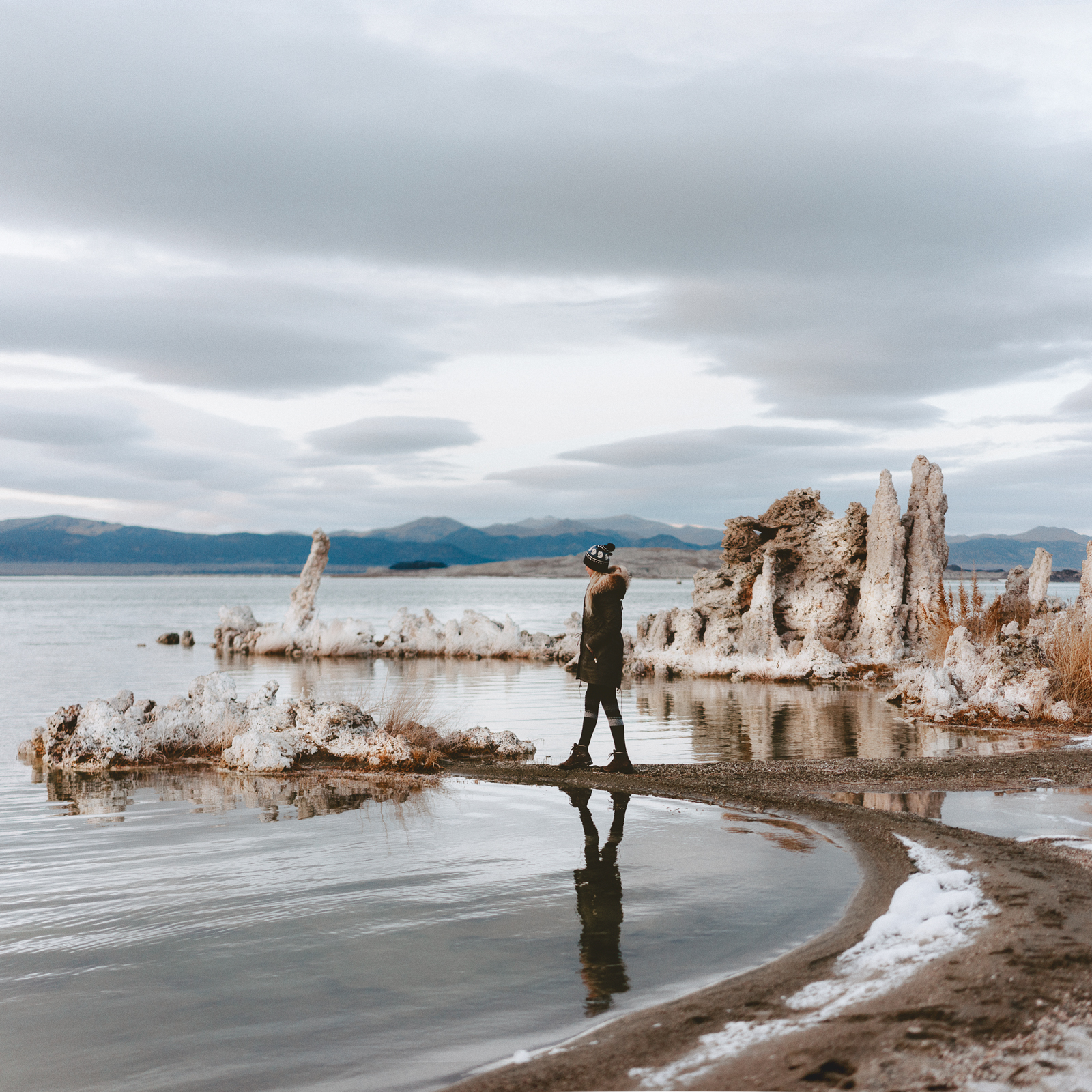 Girl with Fjallraven Hat Walks the Shore of Mono Lake in Mammoth California